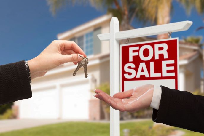 Agent Handing Over House Keys in Front of New Home